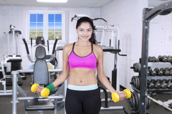 Donna che si allena con i manubri in palestra — Foto Stock