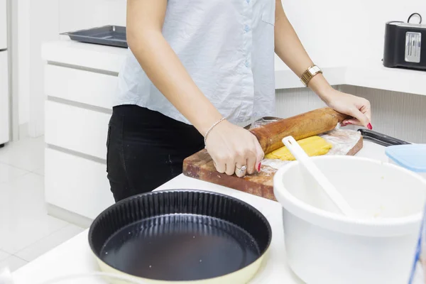 Жінка котиться пиріг тісто на кухні — стокове фото