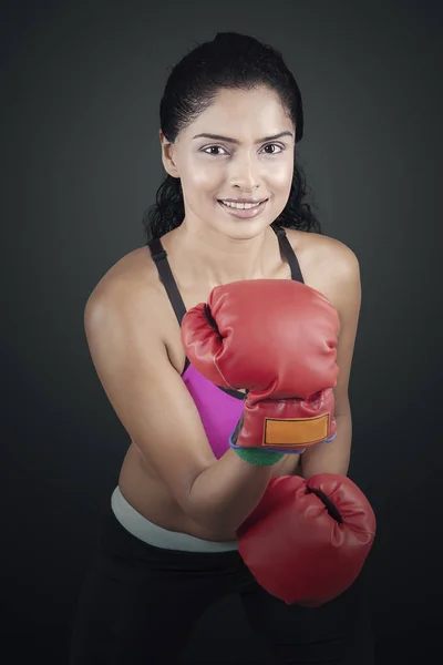 Женщина в боксёрских перчатках на черном фоне — стоковое фото