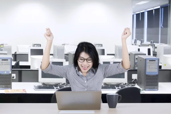 Jovem empresária levantando as mãos no escritório — Fotografia de Stock