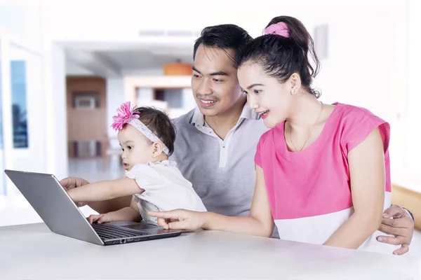 Jeunes parents et enfants utilisant un ordinateur portable — Photo