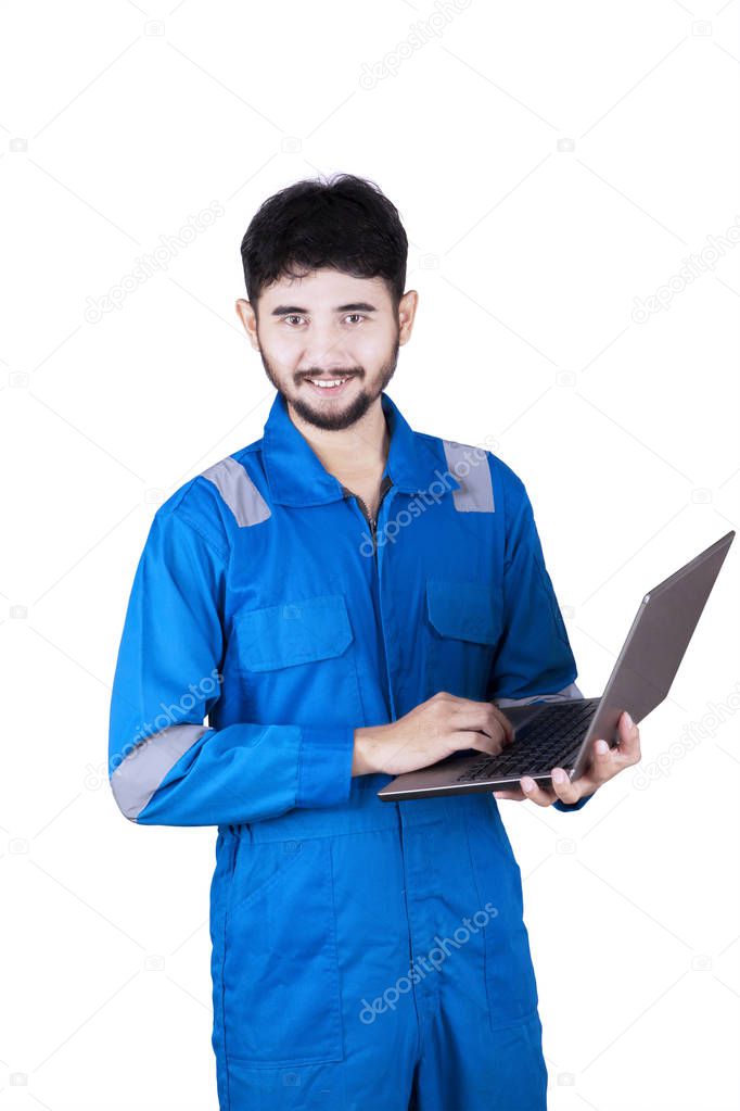 Young mechanic holds laptop 