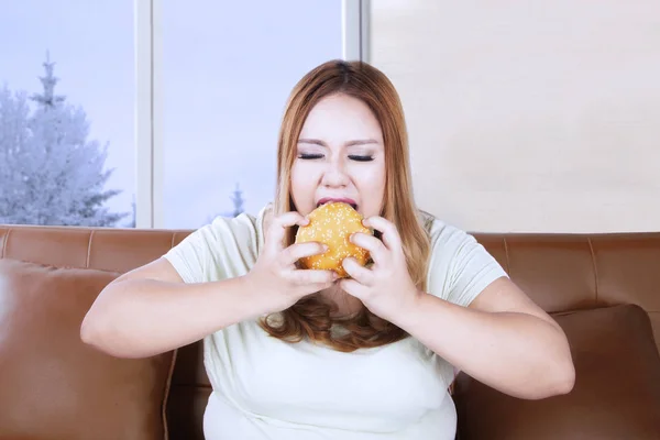 Wütende fettleibige Frau genießt einen Hamburger — Stockfoto