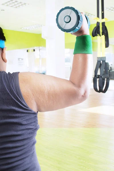 Arm of obese male is lifting barbell — Stock Photo, Image