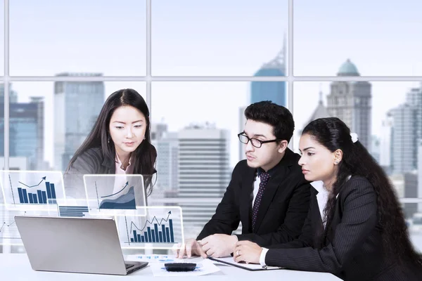 Business team guardando grafico finanziario sul computer portatile — Foto Stock