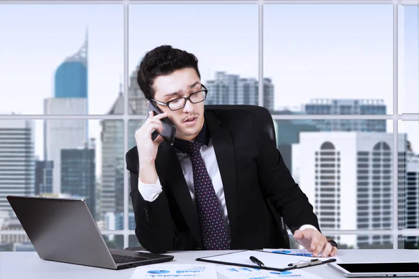 Empresário falando por telefone perto da janela — Fotografia de Stock