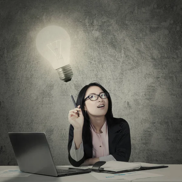Donna d'affari che ha un'idea con una lampadina luminosa — Foto Stock