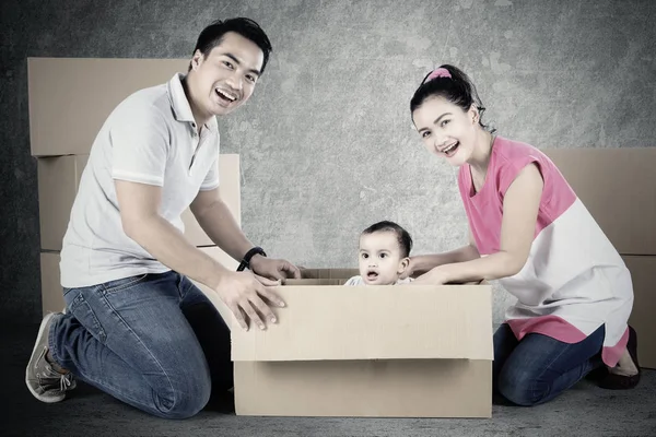 Веселі батьки і дитина грають з коробкою — стокове фото