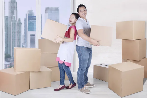 Mulher alegre e homem carregam caixa — Fotografia de Stock