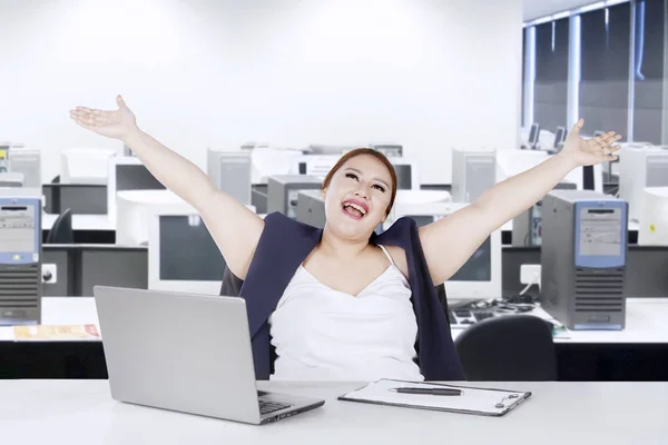 Mulher alegre levantando as mãos no escritório — Fotografia de Stock