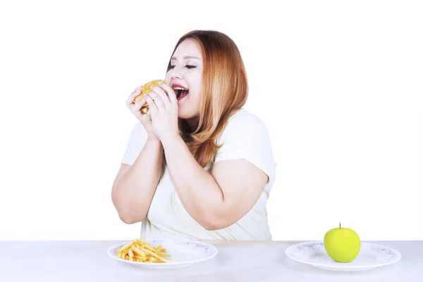 Mujer gorda con comida chatarra y manzana — Foto de Stock