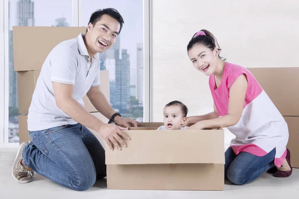 Маленькая дочь и родители играют с коробкой — стоковое фото