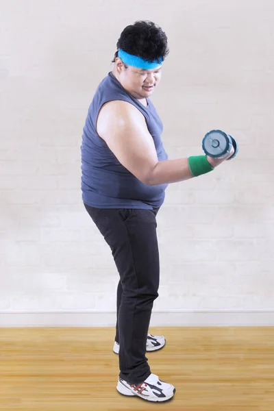 Obese man lifting a dumbbell — Stock Photo, Image
