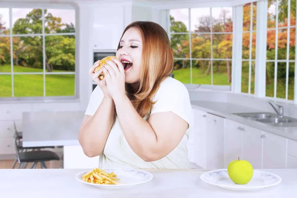 Толстая женщина предпочитает есть нездоровую пищу — стоковое фото