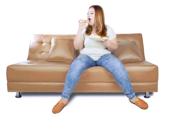 뚱뚱한 여자는 스튜디오에서 도넛을 즐기는 — 스톡 사진