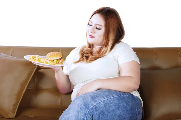 Fettleibige Frau mit Junk Food auf der Couch — Stockfoto