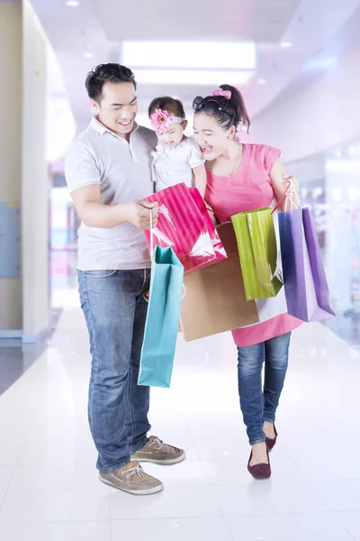 Pais e criança olhando para o saco de compras — Fotografia de Stock