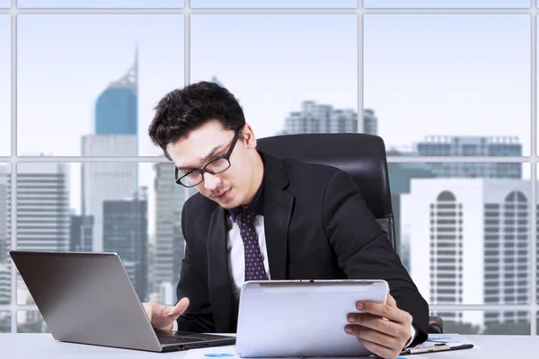 Ernstige zakenman met laptop en digitale tablet — Stockfoto