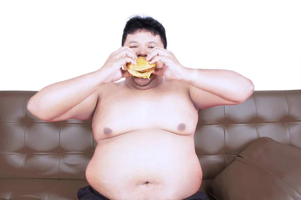 スタジオにハンバーガーを持つ貪欲な肥満男 — ストック写真