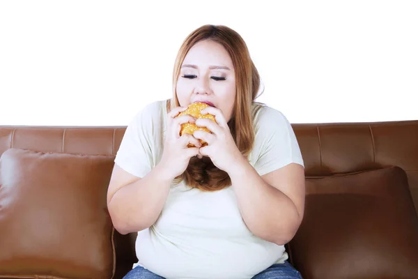 Γυναίκα πεινά με ένα χάμπουργκερ στο στούντιο — Φωτογραφία Αρχείου