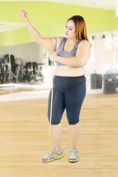 Frau misst ihren Arm im Fitnessstudio — Stockfoto