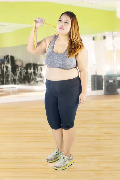 Mujer tira de su cuello en el gimnasio — Foto de Stock