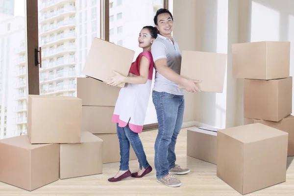 Casal jovem transportando caixa juntos — Fotografia de Stock