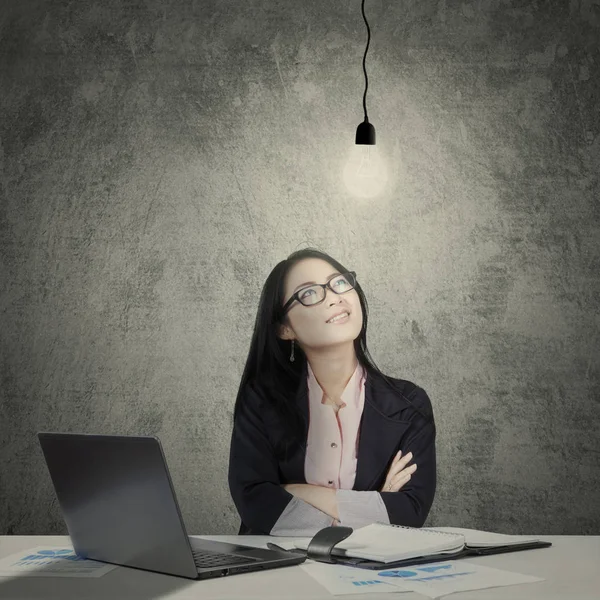 Confident businesswoman looking at a bright lamp Stock Image