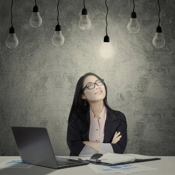 Confident female worker under light bulbs Royalty Free Stock Images