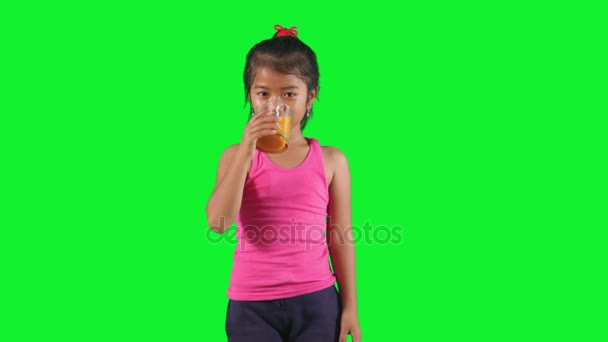 Criança bebe suco de laranja em estúdio — Vídeo de Stock