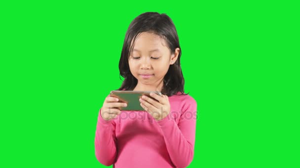 Roztomilá dívka hrající mobil ve studiu — Stock video