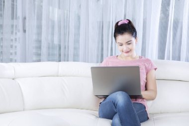 Kadın modeli ile rahat kanepe üstünde laptop