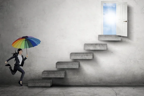 Businesswoman with umbrella leads door — Stock Photo, Image