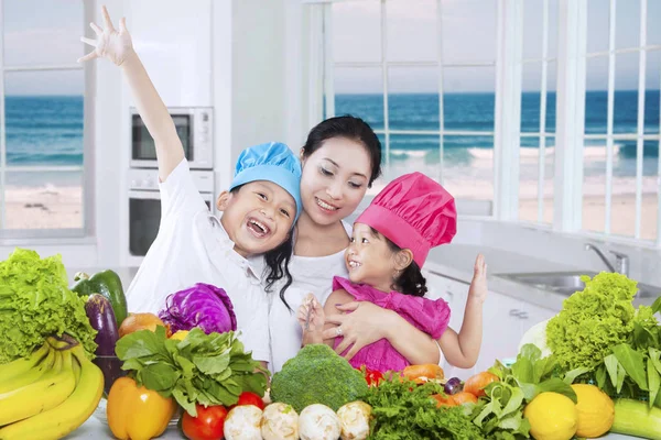 Fröhliche Frau und ihre Kinder kochen Gemüse — Stockfoto