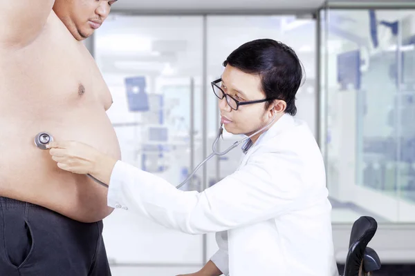 Médico escuchando el estómago del paciente —  Fotos de Stock