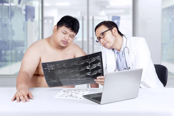 Doctor shows x-ray result on patient — Stock Photo, Image