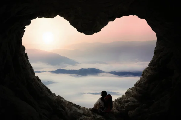 Female backpacker sitting in cave — Stock Photo, Image