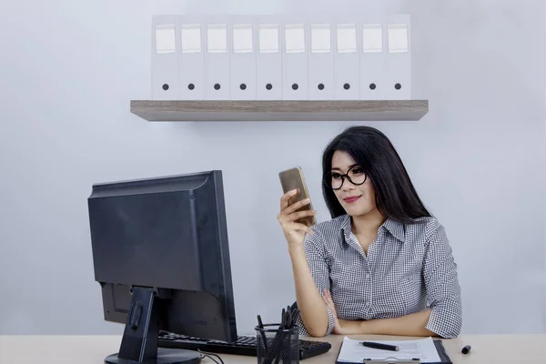 Female entrepreneur looking at cellphone — Stock Photo, Image
