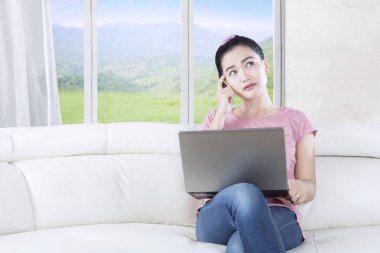 Dalgın laptop oturma odasında kadınla