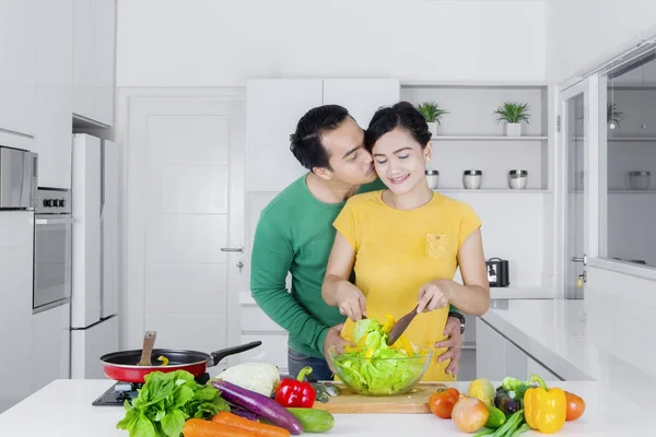 Муж целует жену на кухне. — стоковое фото