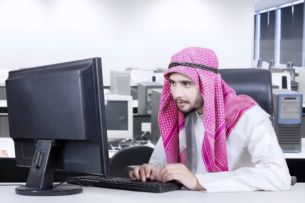 Muslim man typing on keyboard in office — Stock Photo, Image