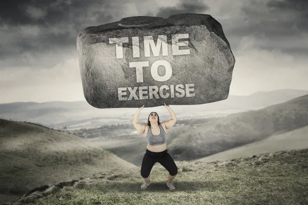 Woman with time to exercise word on stone — Stock Photo, Image