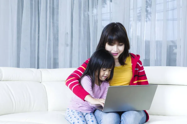 Jovem mãe e criança jogando laptop — Fotografia de Stock