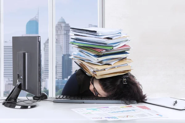 Junge Frau schläft auf Tastatur mit Dokumenten — Stockfoto