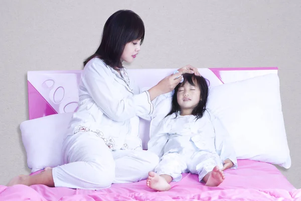 Junge Mutter überprüft Temperatur ihres Mädchens — Stockfoto