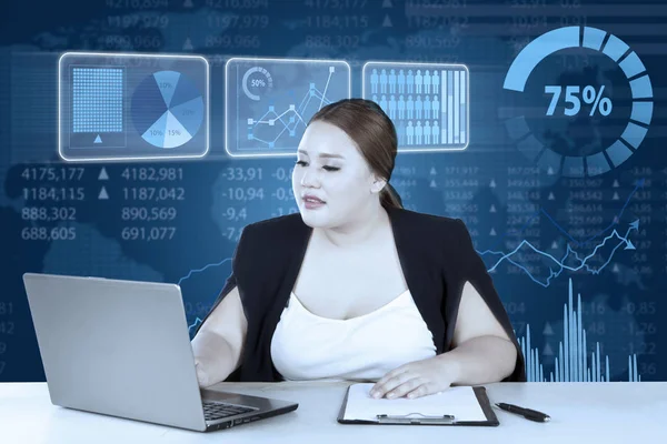 Young entrepreneur works on laptop and clipboard — Stock Photo, Image