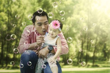 Babası kızını sabunla kabarcık üfleme