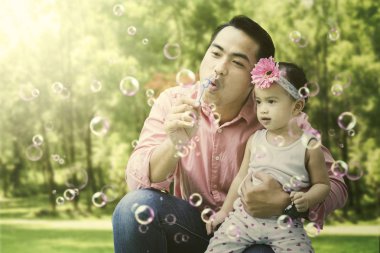 Baba ve kızı sabun köpüğü yaz üzerinde oynamak