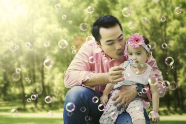 Baba ve kızı sabun köpüğü yapıyor.