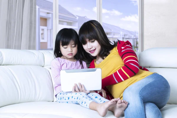 女人和女孩在客厅中使用平板电脑 — 图库照片